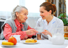 caregiver assisting patient in eating her meal